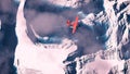 Aerial of red airplane flying over arctic snow landscape with bl