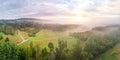Aerial of Riserva Naturale della Marcigliana, tree lines, green meadow, foggy sunset background