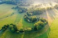 Aerial of Riserva Naturale della Marcigliana with tree lines and green meadow, sun rays flooding