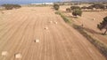 Aerial rising up footage of a man biking on a countryside road in a wheat field