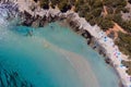 Aerial of Rondinara's populated beach with ships in the sea and trees on the sand