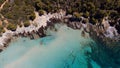 Aerial of Rondinara's populated beach with ships in the sea and trees on the sand