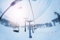 Aerial ropeway with empty chairlifts at foggy day