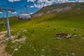 Aerial ropeway high in the mountains of Caucasus with grass plains and cow pastures in the background