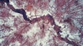 Top view of a narrow winding river in the forest in winter