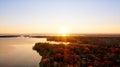 Aerial scenery of a lake surrounded by colorful trees of fall during golden hour Royalty Free Stock Photo