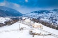 Aerial scenic rural view over Pestera village at the bottom of Piatra-Craiului Mountains during a freezing winter in Romania with Royalty Free Stock Photo