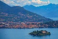 AERIAL: Scenic view of a coastal town and islet in a beautiful Italian lake. Royalty Free Stock Photo