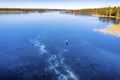 Aerial scenic view: unidentified person ice skating on crystal clear frozen lake in Northern Scandianvia. Clear skies, blue ice,