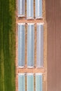 Aerial shot of agricultural greenhouse with plastic sheeting in cultivated field from drone pov