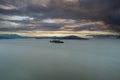 aerial shot of Alcatraz Island with mountain ranges and vast miles of blue ocean water with powerful clouds at sunset Royalty Free Stock Photo