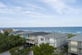 aerial shot along the coast of the Atlantic ocean with beachfront homes, lush green trees and people on the beach with blue sky Royalty Free Stock Photo