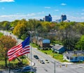 Aerial shot of the American flag and Greensboro, NC skyline on the horizon on a spring day