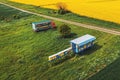 Aerial shot of apiary truck and trailer with beehive boxes in field in spring, drone pov