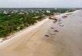An aerial shot from Bagamoyo, Tanzania. Indian Ocean Coast with Vessels and Crowd of people Carrying Catch from