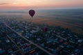 aerial shot of balloon ascending over a sleepy town at dawn