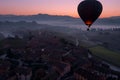 aerial shot of balloon ascending over a sleepy town at dawn