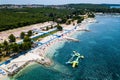 Aerial shot of a beach in Stinjan, Croatia, with green tree-covered land in the background Royalty Free Stock Photo