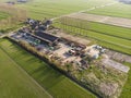 Aerial Shot of a beautiful Farm in The Netherlands surrounded with Bright green Fields in an evening hour