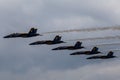 Aerial shot of the Blue Angels aircrafts performing in the air before the clouds Royalty Free Stock Photo