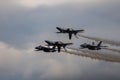 Aerial shot of the Blue Angels formation flying in the air releasing gray smoke Royalty Free Stock Photo