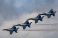 Aerial shot of the Blue Angels performing an air show before the clouds Royalty Free Stock Photo