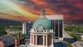 aerial shot of the blue clock tower on top of the Bibb County Courthouse surrounded hotels, office buildings and lush green trees