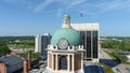 aerial shot of the blue clock tower on top of the Bibb County Courthouse surrounded hotels, office buildings and lush green trees