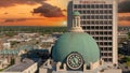 aerial shot of the blue clock tower on top of the Bibb County Courthouse surrounded hotels, office buildings and lush green trees