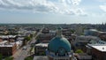 aerial shot of the blue clock tower on top of the Bibb County Courthouse surrounded hotels, office buildings and lush green trees