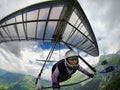 Aerial shot of brave extreme hang glider pilot soaring the therm