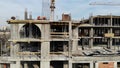 Aerial Shot of the Building in the Process of Construction. Labor working in big construction site.