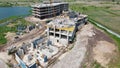 Aerial Shot of the Building in the Process of Construction a house. In the Background Working Crane and city