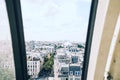 Aerial shot of the buildings of Paris under the cloudy sky captured from a window