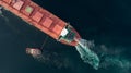 Aerial shot of a cargo ship approaching port with help of towing ship Royalty Free Stock Photo