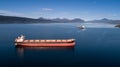Aerial shot of a cargo ship on the open sea with other ship and mountains in the background Royalty Free Stock Photo