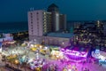 aerial shot of the Carolina Beach Boardwalk with ocean water, people on the beach, hotels and carnival rides with colorful lights Royalty Free Stock Photo