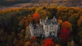 An aerial shot of a castle nestled in the countryside surrounded by vibrant autumn colors. Take a stroll around the Royalty Free Stock Photo