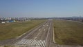 Aerial shot of a city airport plated runway and taxiing aircraft on a sunny day