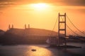 Aerial shot of city buildings, hills, and a bridge over a river at sunset Royalty Free Stock Photo