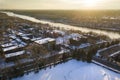 Aerial shot of a city covered with snow near the frozen river in winter Royalty Free Stock Photo