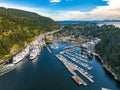 Aerial shot of the city, dense forest and moored boats and ferries at the harbor of Horseshoe Bay