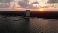 Aerial shot of the coastline and a resort with a wood boat dock at sunset.