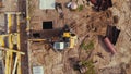 Aerial shot of a construction site. Workers dressed in high-visibility jackets supervising the work of an excavator Royalty Free Stock Photo