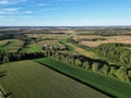 Aerial shot of a countryside with wide green agricultural fields and forests Royalty Free Stock Photo