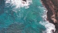 Aerial shot from drone. Top view on the rocky ocean shore. Blue Waves of the Pacific Ocean is crashing on the rock Royalty Free Stock Photo