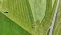 Aerial shot with drone of two tractors harvesting hay in a meadow in Bavaria