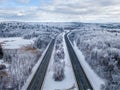 Aerial shot of empty highway roads next to each other along winter landscape Royalty Free Stock Photo