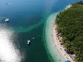 Aerial shot of an exotic beach resort with tiki huts and tourist boats