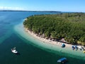 Aerial shot of an exotic beach resort with tiki huts and tourist boats